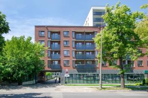 a red brick building with a tree in front of it at Apartament G312 Łódź Jana Matejki 11 in Łódź