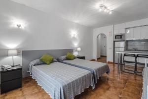 a bedroom with a large bed and a kitchen at Bleu Torviscas in Adeje