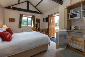 a bedroom with a large bed and a kitchen at Rawcliffe House Farm in Pickering