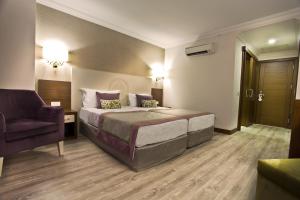 een hotelkamer met een bed en een stoel bij Side Alegria Hotel & Spa - All Inclusive-Adult Only in Side