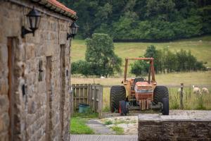 a tractor parked in a field next to a fence at Rawcliffe House Farm in Pickering