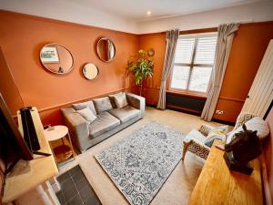 a living room with a couch and a rug at Unique & Stylish Town House, central Cheltenham in Cheltenham