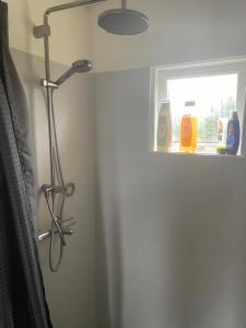 a shower head in a bathroom with a window at Hulduhólar Cabin - The Elf Hills. in Selfoss