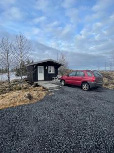 a car parked in front of a tiny house at Hulduhólar Cabin - The Elf Hills. in Selfoss