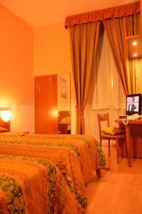 a hotel room with two beds and a desk at Hotel Genova in La Spezia