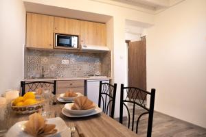 una cucina con tavolo in legno con sedie e una sala da pranzo di THE WALK INN apartments a Città di Rodi