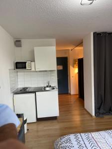 a room with a kitchen with a counter and a microwave at Les Logis de Paray Appartement 202 in Paray-le-Monial