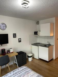a kitchen with a counter and a table and a clock at Les Logis de Paray Appartement 202 in Paray-le-Monial