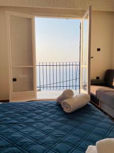 Pokój z łóżkiem i dużymi przesuwnymi szklanymi drzwiami w obiekcie Άκρη του κόσμου w mieście Samos