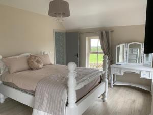 a bedroom with a white bed and a mirror at Sage Gables Mourne Mountains in Annalong