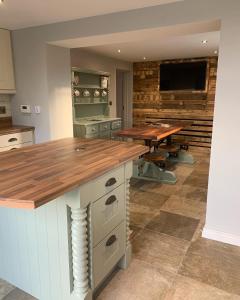a kitchen with a wooden counter and a table at Sage Gables Mourne Mountains in Annalong