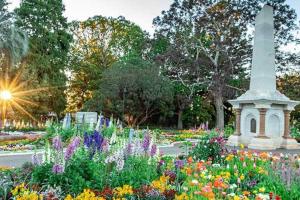 a garden with flowers and a monument in the background at Studio Apartment in East Toowoomba in Toowoomba