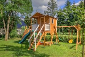 une maison de jeu en bois avec toboggan dans l'établissement Beskidzka Przystań, 