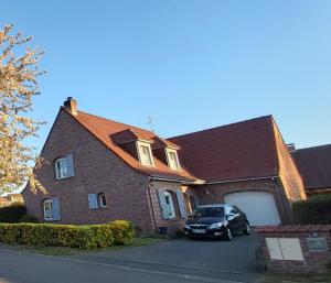 un coche aparcado frente a una casa de ladrillo en 2 Chambres de 16m2 à 10kms de Lille, en Beaucamps-Ligny
