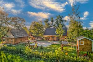 une maison en rondins avec une cour et une aire de jeux dans l'établissement Beskidzka Przystań, 