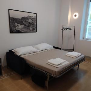 a bed with two towels on it in a room at Apartments for you 2 in Matera