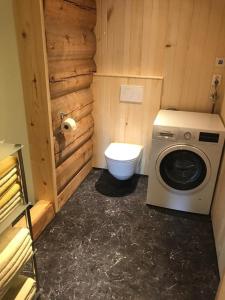 a small bathroom with a toilet and a washing machine at Tjonnas Farm Stay in Sauland