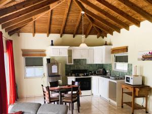 a kitchen with white cabinets and a table and chairs at Bay View condo in Philipsburg