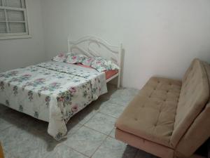 a bedroom with a bed and a chair at Apartamento com churrasqueira, ótima localização. in Cachoeira do Sul