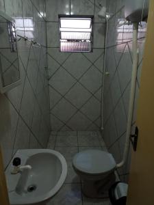 a small bathroom with a toilet and a sink at Apartamento com churrasqueira, ótima localização. in Cachoeira do Sul