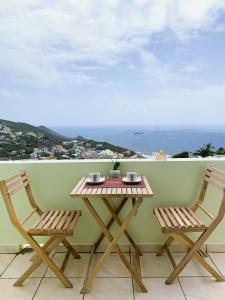 uma mesa e duas cadeiras numa varanda com o oceano em Bay View condo em Philipsburg