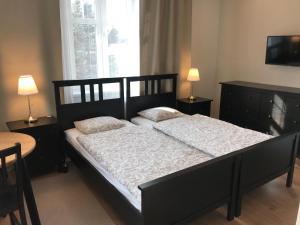 a bedroom with a large black bed with two pillows at Belgard- House 32 in Białogard