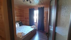 ein kleines Schlafzimmer mit einem Bett und einem Fenster in der Unterkunft Вила ВлаиДа in Saparewa Banja