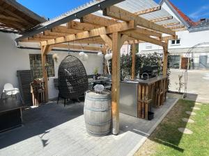 a wooden pergola with a table and a barrel at Sali Homes - Bergerie in Obersulm