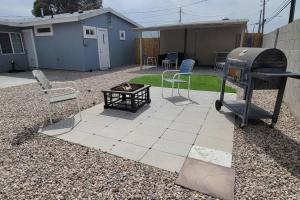 a backyard with a fire pit and a grill and chairs at K - Fully remodeled and professionally decorated in Las Vegas