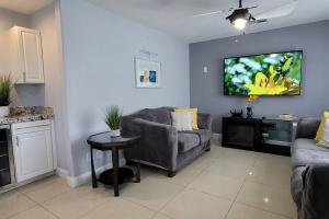 a living room with a couch and a tv on the wall at K - Fully remodeled and professionally decorated in Las Vegas