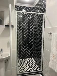 a shower with a glass door in a bathroom at Zindiza Guesthouse in Witbank