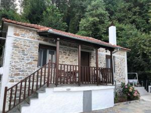a small stone house with a wooden balcony at Infinity Guest House in Kissos