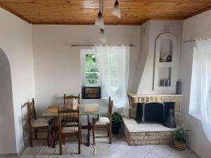 a dining room with a table and a fireplace at Infinity Guest House in Kissos