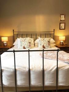 1 dormitorio con 1 cama con sábanas y almohadas blancas en Church Mouse Cottage Clitheroe en Clitheroe