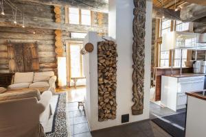een woonkamer met een stapel brandhout aan de muur bij LevinPesä Chalet in Levi