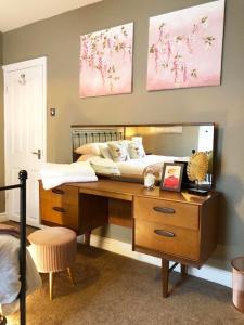 een slaapkamer met een bed en een houten bureau met een bureau bij Church Mouse Cottage Clitheroe in Clitheroe