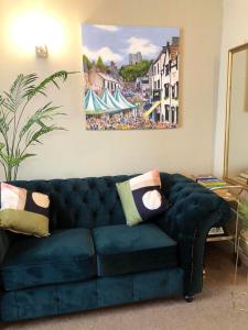 a blue couch in a living room with a painting at Church Mouse Cottage Clitheroe in Clitheroe