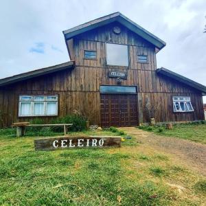 un edificio de madera con un cartel delante en Celeiro Moderno em Guarapuava - Hospedagem Única para até 10 pessoas a 8km do centro, en Guarapuava
