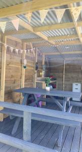 a picnic table in a cabin with a wooden ceiling at Bell tent 3 Glyncoch isaf farm in Llwyn-Dafydd