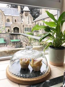 a glass dish with two muffins on a table at Church Mouse Cottage Clitheroe in Clitheroe