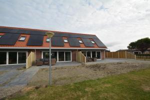 una casa con paneles solares en el techo en Duinpan, en Serooskerke