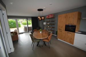 una cucina e una sala da pranzo con tavolo e sedie di Golfbreker a Serooskerke