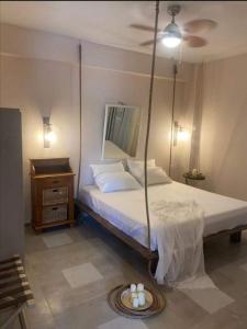 ein Schlafzimmer mit einem Schaukelbett und einem Tisch in der Unterkunft Boho Vibes in Arménoi