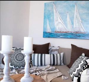 uma sala de estar com um sofá e uma pintura de veleiros em Boho Vibes em Arménoi
