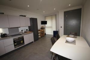 a kitchen with a table and a white counter top at Hendon Place in The Hyde