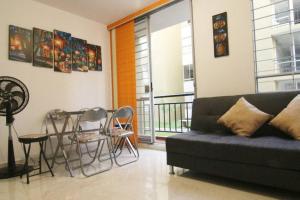 sala de estar con sofá, mesa y balcón en Relájate o teletrabaja en lindo apto, 3 hab y WiFi, en Villavicencio