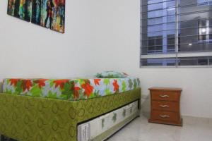 a bedroom with a green couch and a window at Relájate o teletrabaja en lindo apto, 3 hab y WiFi in Villavicencio +18 photos