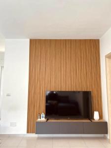 a living room with a large flat screen tv on a wall at Pine Breeze Apartment Gjiri i Lalezit in Draç +8 photos