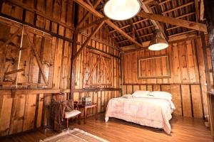 Un dormitorio con una cama en una cabaña de madera. en Celeiro Moderno em Guarapuava - Hospedagem Única para até 10 pessoas a 8km do centro, en Guarapuava