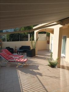 eine Terrasse mit einer roten Bank und einer Couch in der Unterkunft Très bel appartement entier proche de la mer 2 chambres 1 salon in Vallauris